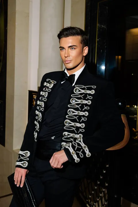 Male model in embroidered black jacket and bow tie with groomed hair
