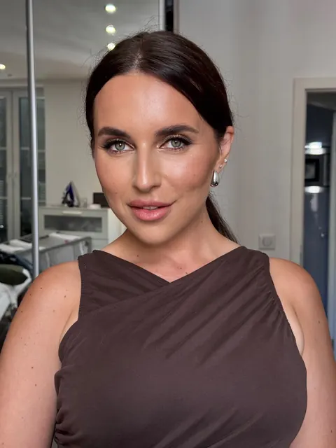 Soft glam makeup with sleek low bun and defined brows, portrait in a beauty studio