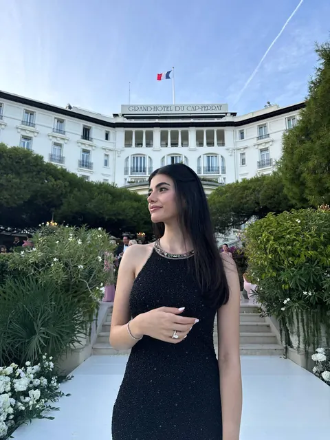 Woman in black sparkly dress in front of the Grand-Hôtel du Cap-Ferrat
